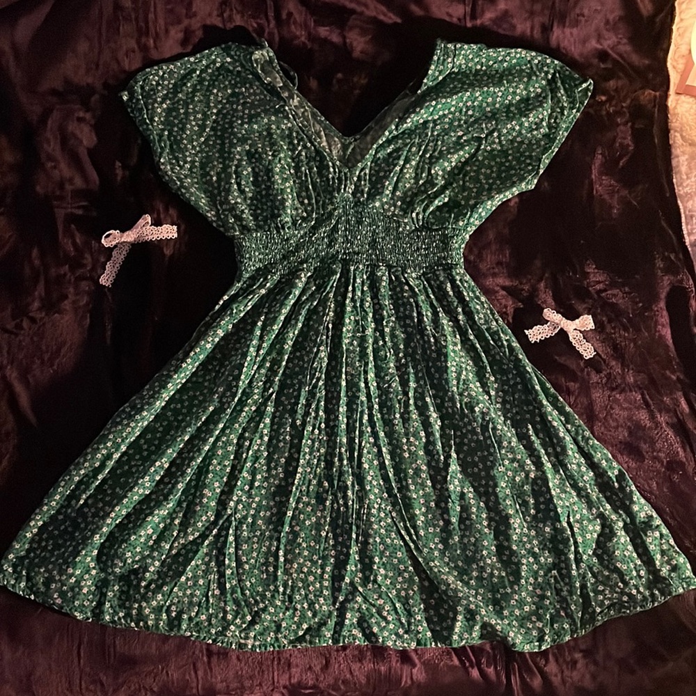 green mini flowy dress with accents of blue and white flowers
